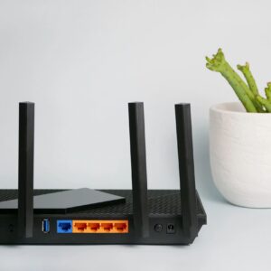 Black wireless router providing network technology for internet connection.